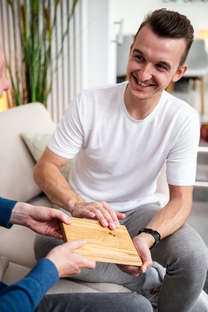 Ein Mitarbeitender sitzt im Showroom und lächelt in Richtung einer Person