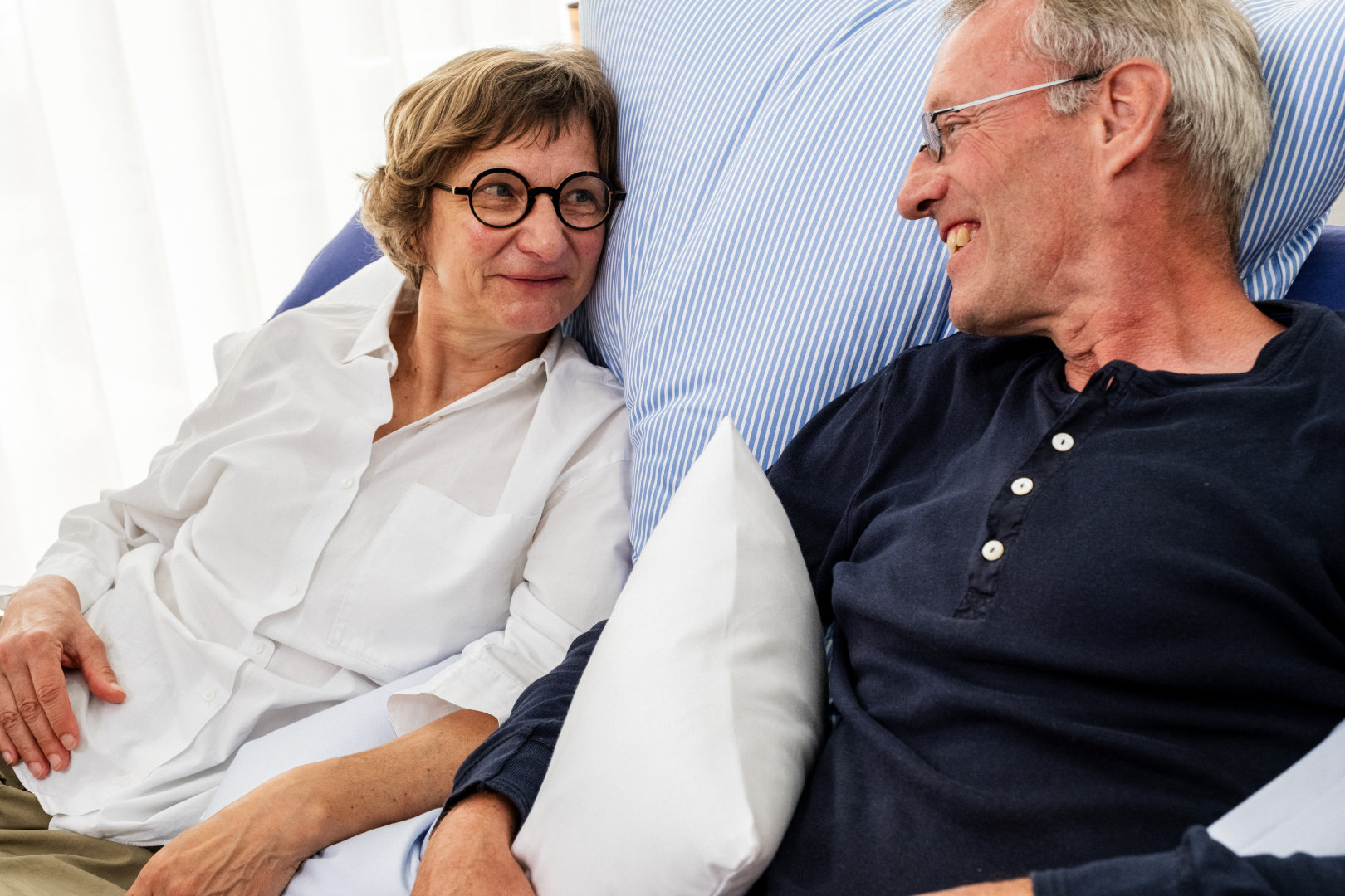 Zufriedenes Paar liegt entspannt im Bett nach der Beratung bei Betten VIKINGS